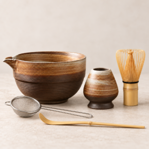 Front view of 5-piece rustic ceramic matcha set with bowl, whisk holder, bamboo whisk, scoop and metal strainer